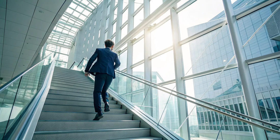 A professional takes steps toward upward mobility by climbing a staircase in a modern office.
